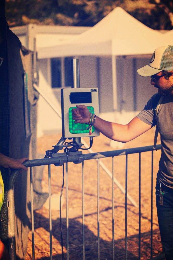 Attendee taps an RFID wristband on a Tixify gate reader